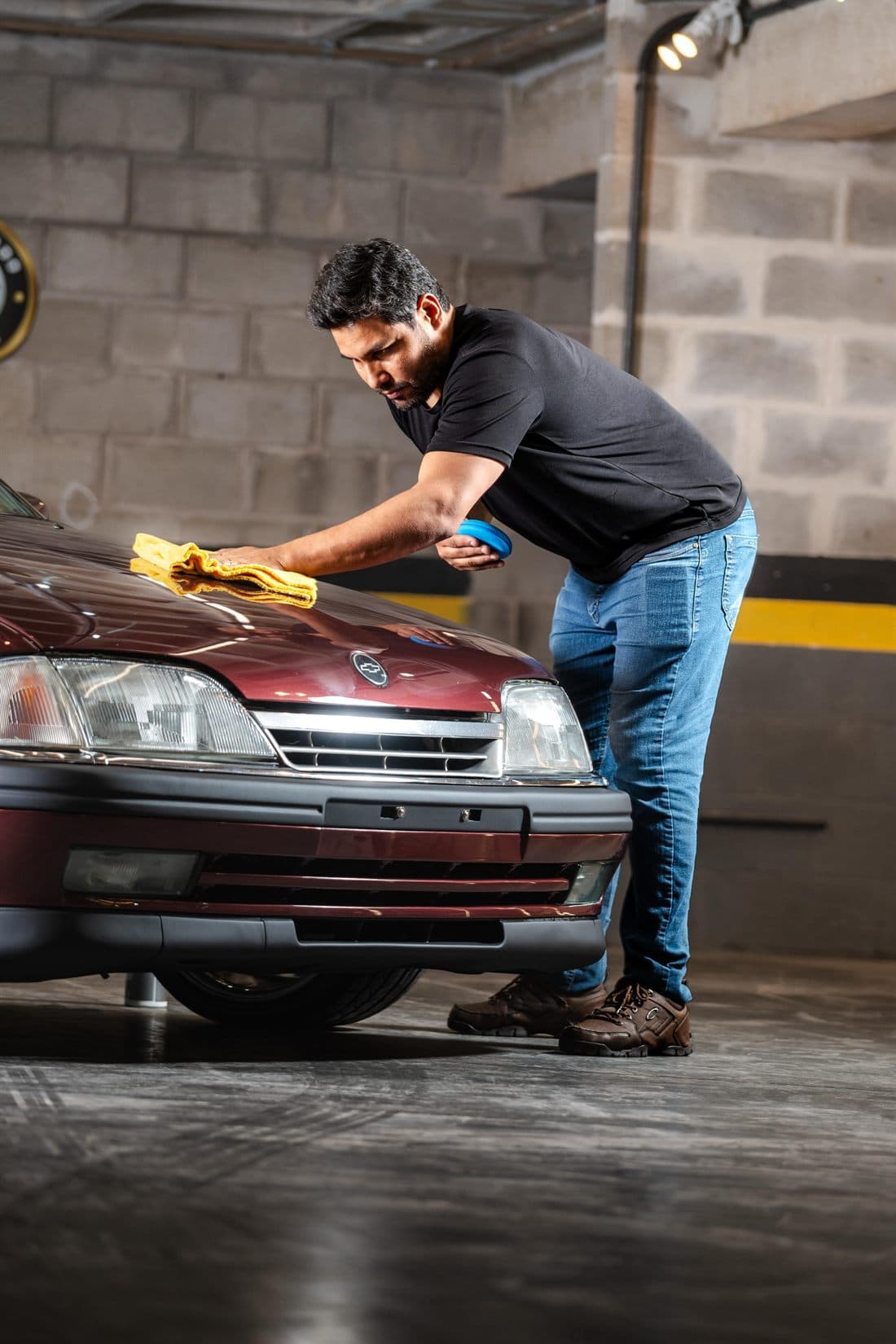 Felipe finalizando a pintura de um clássico dentro da oficina da V8